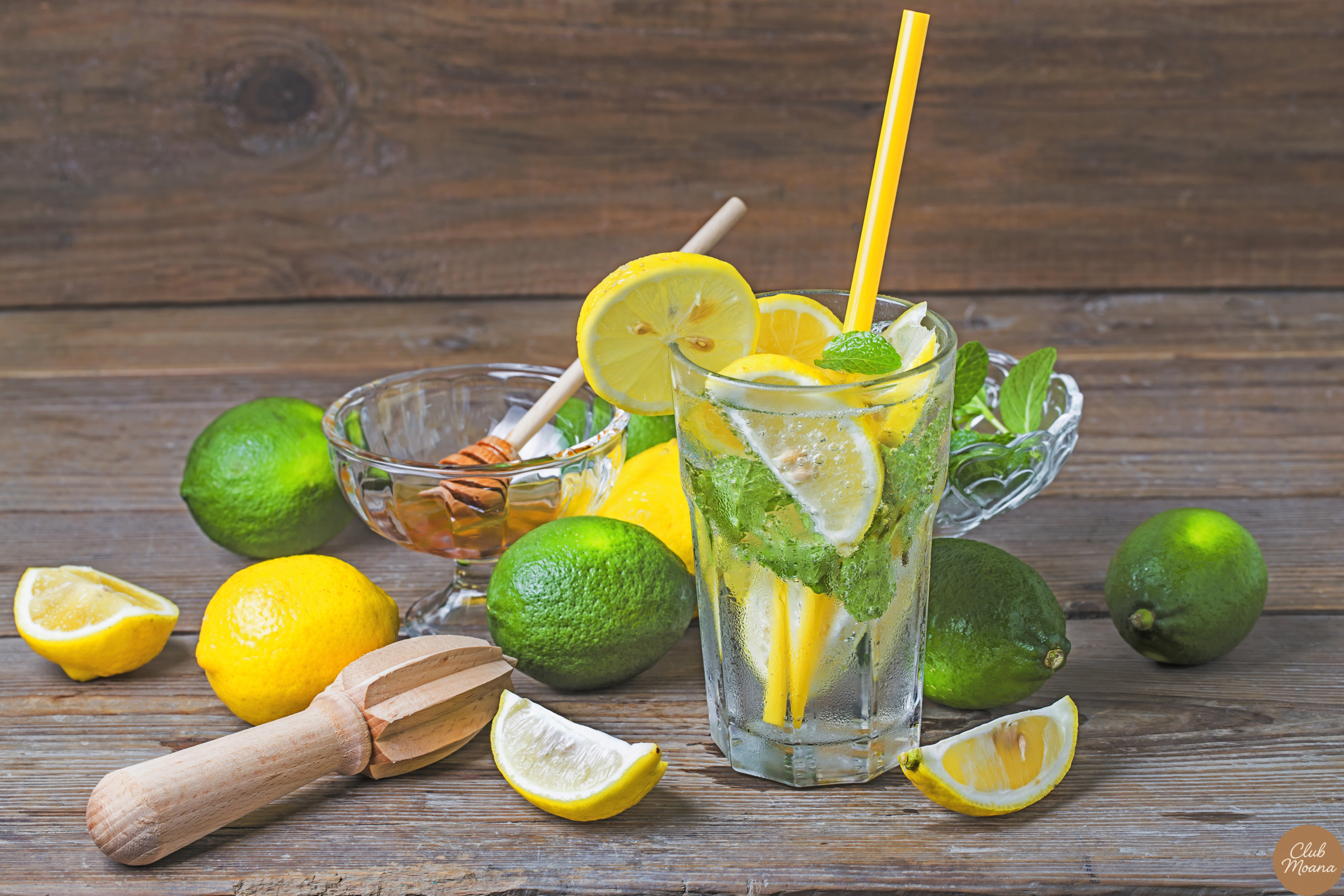 A close-up shot of a glass of water with lemon on a wooden table