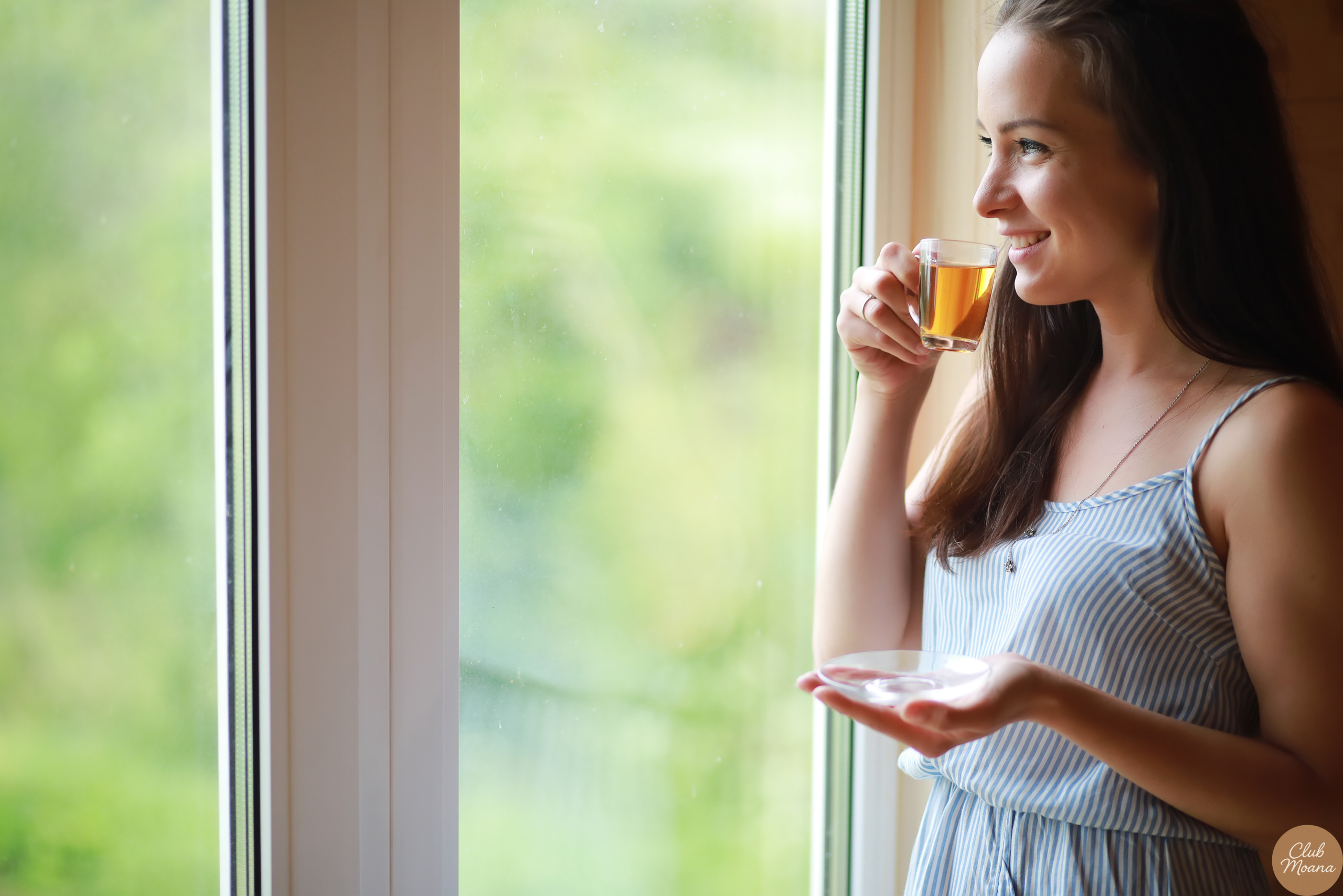 A morning shot of someone stretching, holding a cup of herbal tea