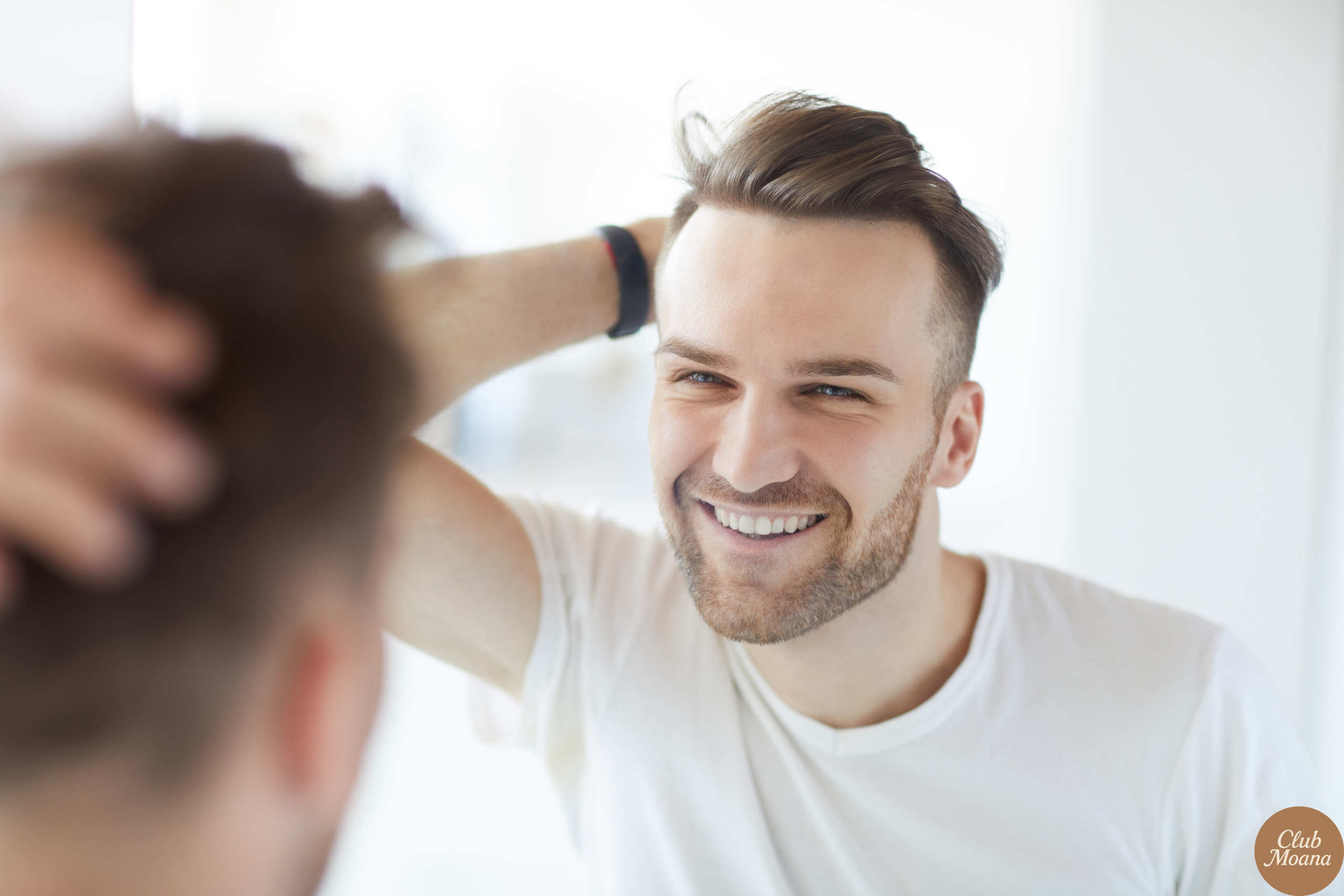 A confident man looking in the mirror or smiling outdoors