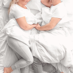 A happy couple or smiling in a bedroom setting