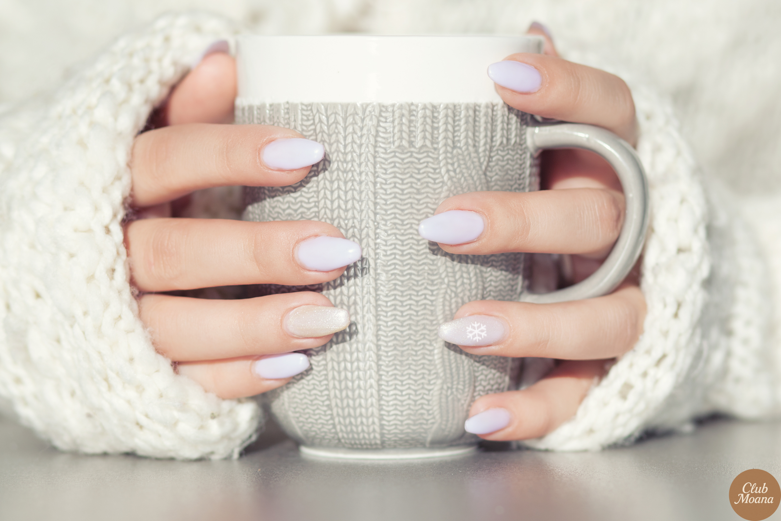 Hand holding a cup of coffee with nude nails