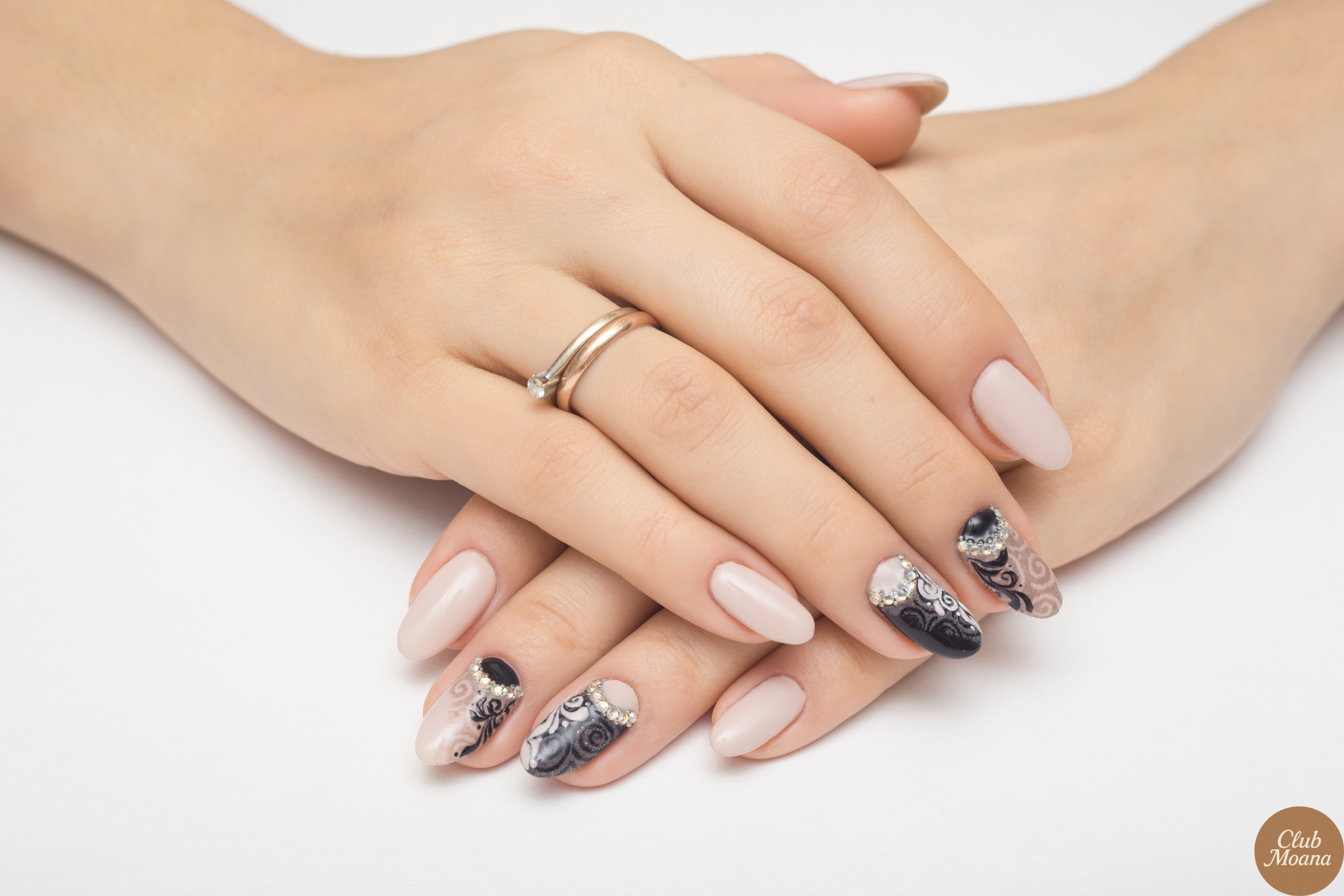 Nude nail design against neutral background with jewelry