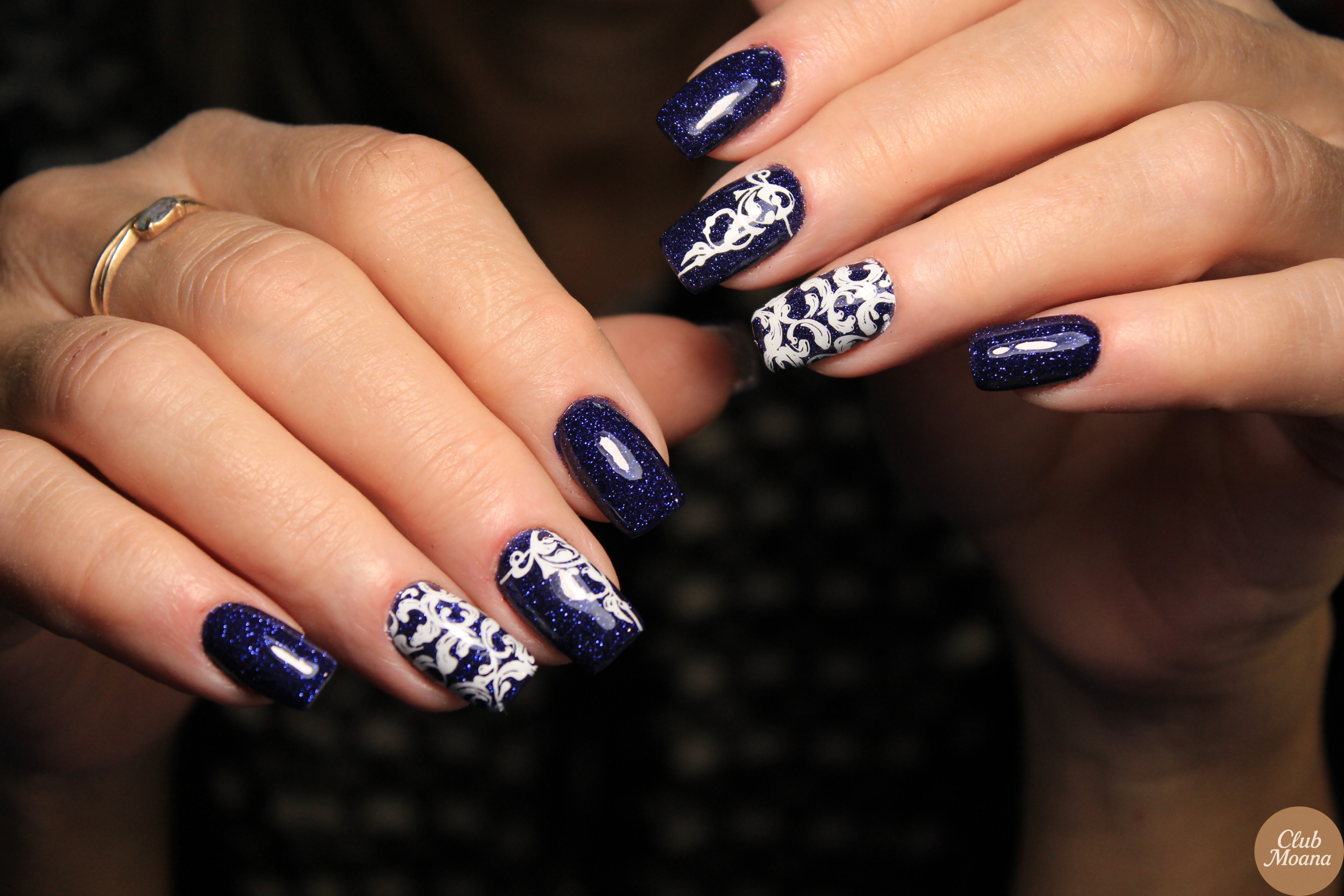 White snowflake art on navy blue nails