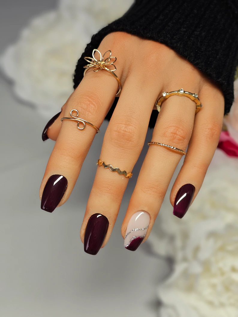 Plum nails with gold jewelry